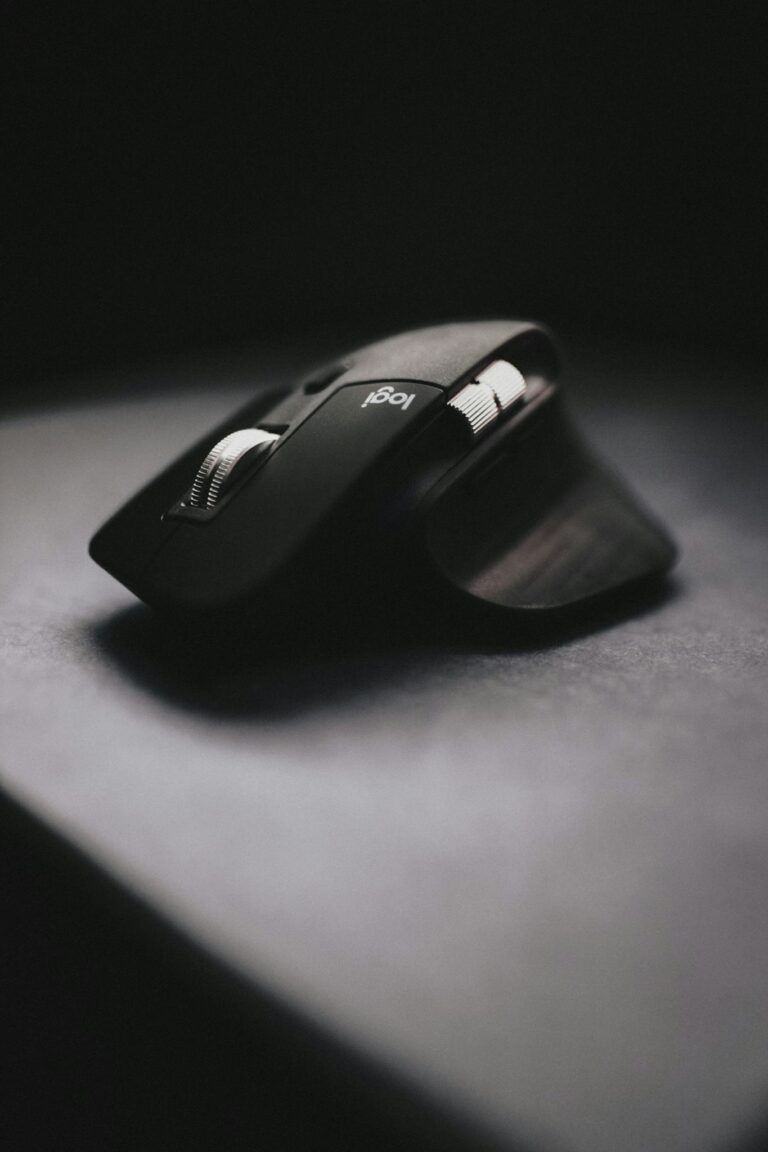 Close-up of a sleek ergonomic wireless mouse on a dark surface, emphasizing design and technology.